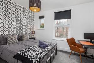 Un dormitorio con una cama, un escritorio y una computadora. en Heart of the City-Flexi Cancellations-Central Hub, en Sheffield