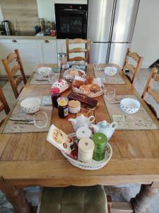 a wooden table with food and dishes on it at Les logis de La Tribu in Jouaignes