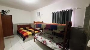 a bedroom with two bunk beds and a chair at Enseadabechouse in Cabo de Santo Agostinho +9 photos