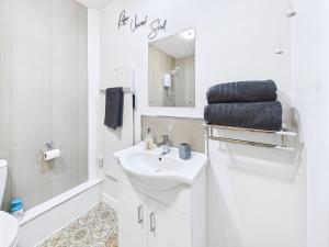 a white bathroom with a sink and a mirror at Bijou Abode- bungalow- free private parking and secure cabin in Great Driffield +15 photos