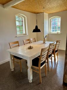 a dining room with a white table and chairs at Charming apartment by forest & beach on Tåsinge in Svendborg