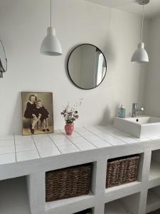 a bathroom counter with a sink and a mirror at Charming apartment by forest & beach on Tåsinge in Svendborg +23 photos