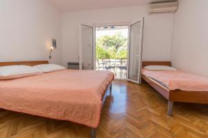a bedroom with two beds and a balcony at Apartment Family Ribicic in Mandre