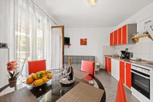 a kitchen with a table with a bowl of fruit on it at Apartments Fjord in Brajkovići