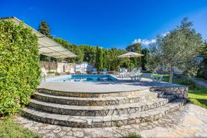 a swimming pool with stairs next to a yard at Apartments Fjord in Brajkovići