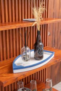 a shelf with two vases sitting on a plate at Cadejo Brewing Company El Sunzal in Tamanique +30 photos