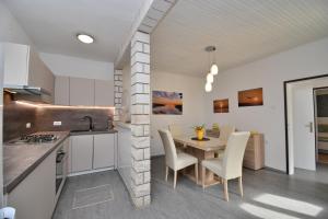 a kitchen and dining room with a table and chairs at Apartment Martelina in Manjadvorci