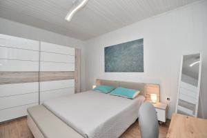 a white bedroom with a bed and a window at Apartment Martelina in Manjadvorci