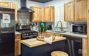 Una cocina con gabinetes de madera y un refrigerador negro. en Yvonnies-Super Cool Convenient Comfy & Renovated Cabin, en Ruidoso