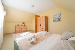 a bedroom with two beds with towels on them at Varga Apartman Balatonberény in Balatonberény