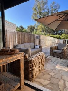 un patio avec deux chaises et un parasol dans l'établissement Charmant mazet avec piscine privée proche plage et commerces à trois mn à pied à la Croix Valmer, à La Croix-Valmer