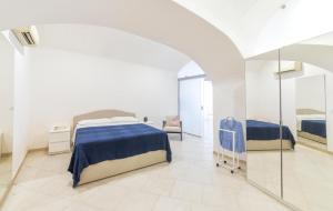 a white bedroom with a bed and a mirror at O'Vascio Sant'Angelo in Serrara Fontana