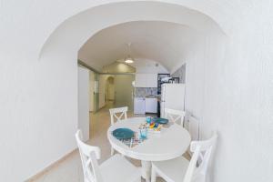 a white dining room with a white table and chairs at O'Vascio Sant'Angelo in Serrara Fontana +6 photos