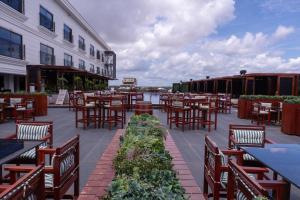 an outdoor patio with tables and chairs and a building at Yogh Hospitality in Paramaribo