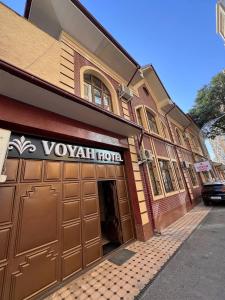 a building with a vaughan hotel sign on it at Voyah Hotel in Tashkent