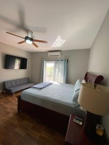 a bedroom with a bed and a ceiling fan at Spacious Beach House with Pool in Gated Community 