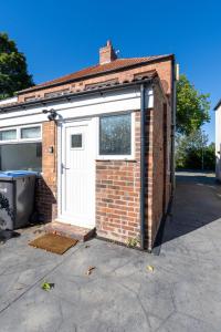 a brick building with a white door and a window at Spenny Homestay - Monthly & Weekly Stays in Byers Green