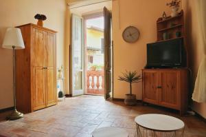 ein Wohnzimmer mit Fernseher, Tisch und Uhr in der Unterkunft Decio's Balcony in Spello