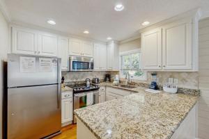 een keuken met witte kasten en een roestvrijstalen koelkast bij Pelican Bay 42 in Isle of Palms +20 foto's