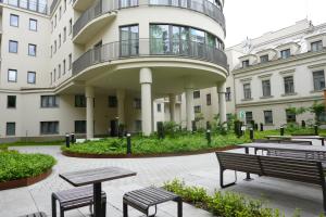 ein Gebäude mit Bänken und Tischen davor in der Unterkunft Smoleńsk 33 Luxury Apartment in Krakau