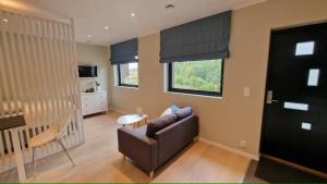 a living room with a couch and a table at Comfortable apartment with free parking in Spydeberg