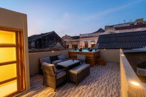 d'un balcon sur le toit avec une table et des chaises. dans l'établissement 7BR Walled City Diamond Villa - Rooftop Heated Jacuzzi, à Carthagène des Indes