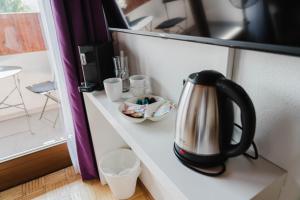 a tea kettle sitting on a counter next to a window at Studio Emi in Schiefling am See +3 photos
