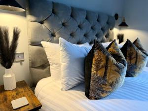 a bedroom with a bed with pillows and a blue headboard at 3 West End Boutique Apartment in Bowness-on-Windermere
