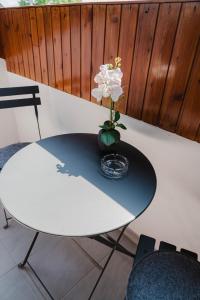 a table with a vase with a white flower on it at Studio Emi in Schiefling am See