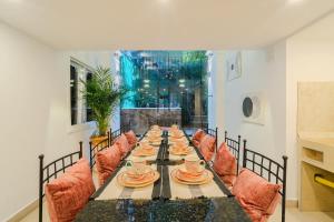a long table with chairs and plates on it at Walled City 9BR Luxury Villa - Jacuzzi & Pool Table in Cartagena de Indias