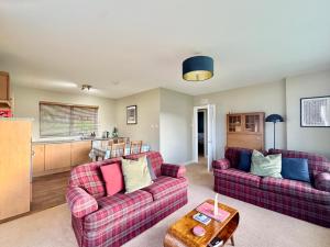 a living room with two couches and a table at Ash, Birch and Rowan Self Catering Cabins in Onich +48 photos