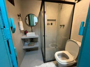 a bathroom with a toilet and a shower with a mirror at Pousada Tatuamar Café & Bistrô - 150 m da praia in Pôrto de Pedras +35 photos