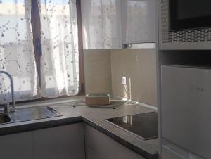 a small kitchen with a sink and a microwave at Casa Alkama in Playa Honda