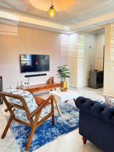 a living room with a couch and a tv at Oasis Villas- Naalya in Kampala