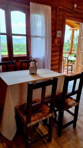 Una mesa y sillas en una habitación con ventana. en Cabaña La Vista, en La Caldera