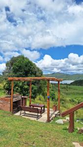 un refugio de picnic con un banco en un campo en Cabaña La Vista, en La Caldera 7 fotos más