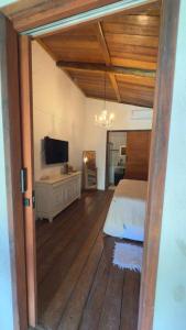 a bedroom with a bed and a television in it at Pousada Tatuamar Café & Bistrô - 150 m da praia in Pôrto de Pedras