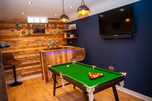 a room with a pool table and a bar at Ye Olde Cottage in Crawley