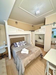 ein Schlafzimmer mit einem Bett, einem Schreibtisch und einem Tisch in der Unterkunft Estúdio no Centro Reformado e Decorado in Nova Friburgo