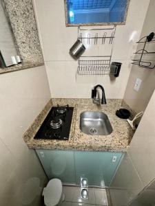 eine kleine Küche mit Spüle und Herd in der Unterkunft Estúdio no Centro Reformado e Decorado in Nova Friburgo