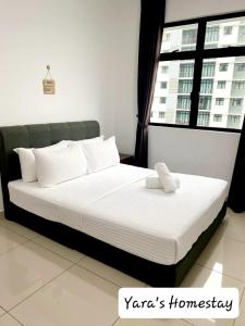 un grand lit dans une chambre avec une fenêtre dans l'établissement Yara's Homestay at Desaru Utama Residence, à Bandar Penawar
