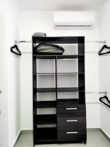 a black closet with shelves and a light at Moderno y comodo Depto con terraza y alberca in Naranjo +51 photos