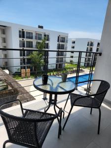 a patio with a table and chairs on a balcony at Moderno y comodo Depto con terraza y alberca in Naranjo