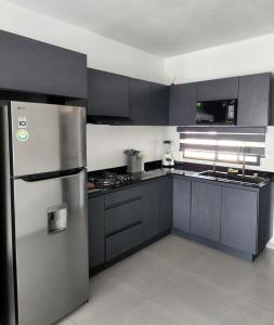 NaranjoにあるModerno y comodo Depto con terraza y albercaのキッチン(黒いキャビネット、ステンレス製の冷蔵庫付) +65枚の写真