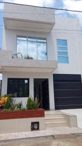 a white house with a black garage at Villa M&G Mompox in Santa Cruz de Mompox