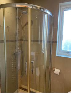 a shower with a glass door in a bathroom at Stunning Studio1, Banstead with free off st parking in Banstead