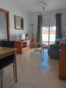 un salon avec un canapé et une télévision dans l'établissement One-bedroom flat 200m from the beach, à Almería