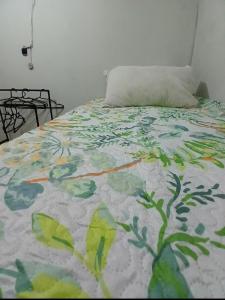 Una cama con un edredón colorido y una almohada. en Rodrigues Hostel, en Río de Janeiro