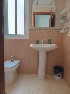 une salle de bain avec un lavabo, des toilettes et un miroir dans l'établissement One-bedroom flat 200m from the beach, à Almería