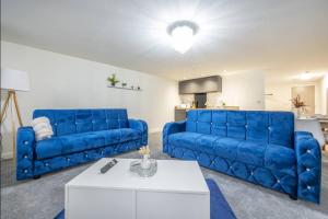 a living room with two blue couches and a table at Navy Diamond Apartment in Bradford! in Bradford +15 photos